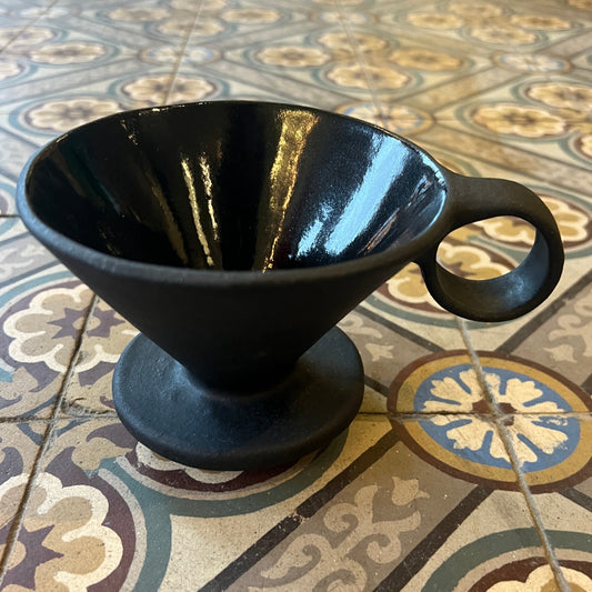 Svart Kaffi drypp i handlaga keramikk