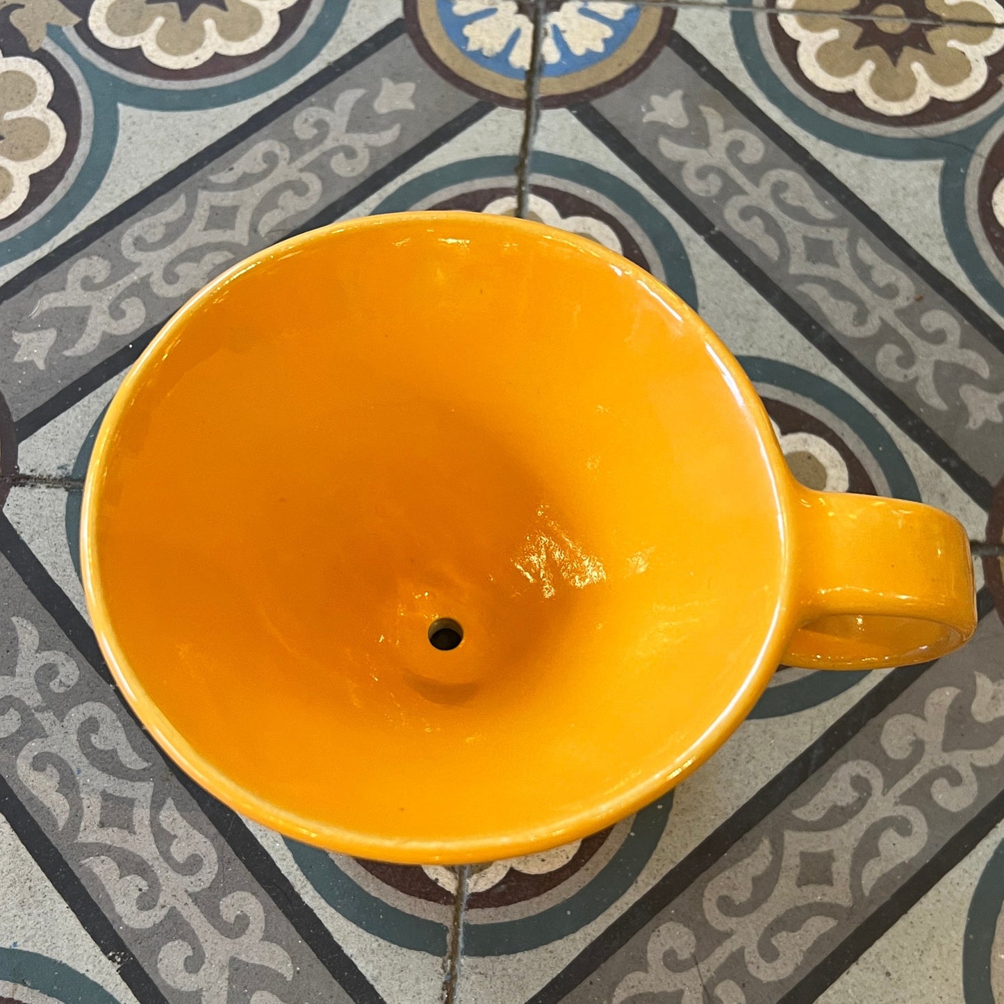 Orange Kaffi drypp i handlaga keramikk