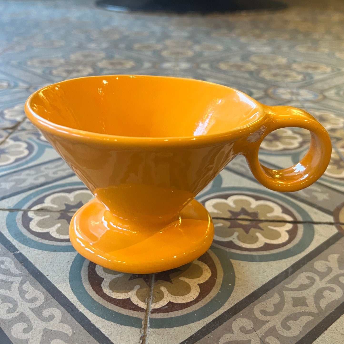 Orange Kaffi drypp i handlaga keramikk